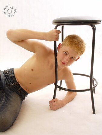 Nude redhead twink Willy poses comfortably in a chair