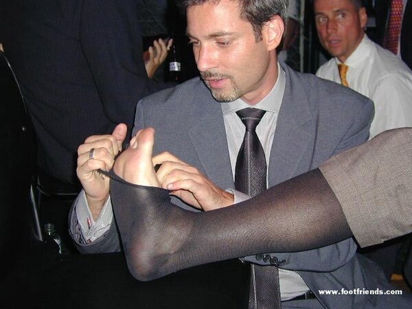 Men in suits gather for a thrilling foot fetish party