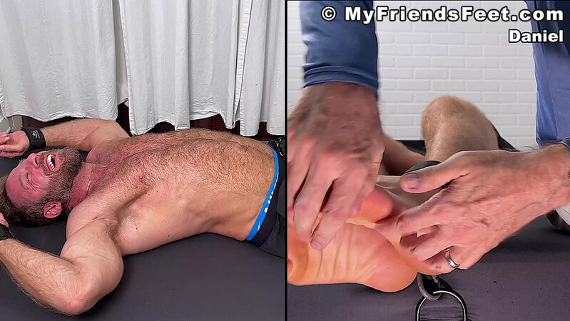 Daniel squirms as Dan Edwards tickles his bare feet