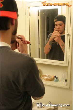 Zack smokes a cigarette while shaving in bathroom
