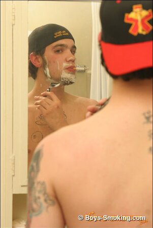 Zack smokes a cigarette while shaving in bathroom