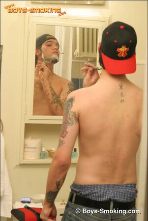 Zack smokes a cigarette while shaving in bathroom