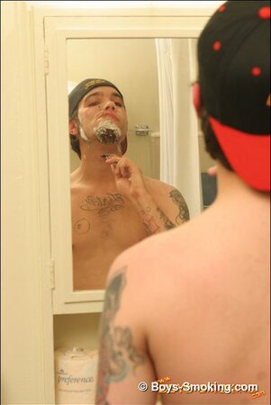 Zack smokes a cigarette while shaving in bathroom