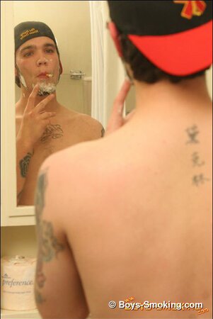 Zack smokes a cigarette while shaving in bathroom