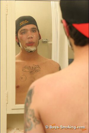 Zack smokes a cigarette while shaving in bathroom